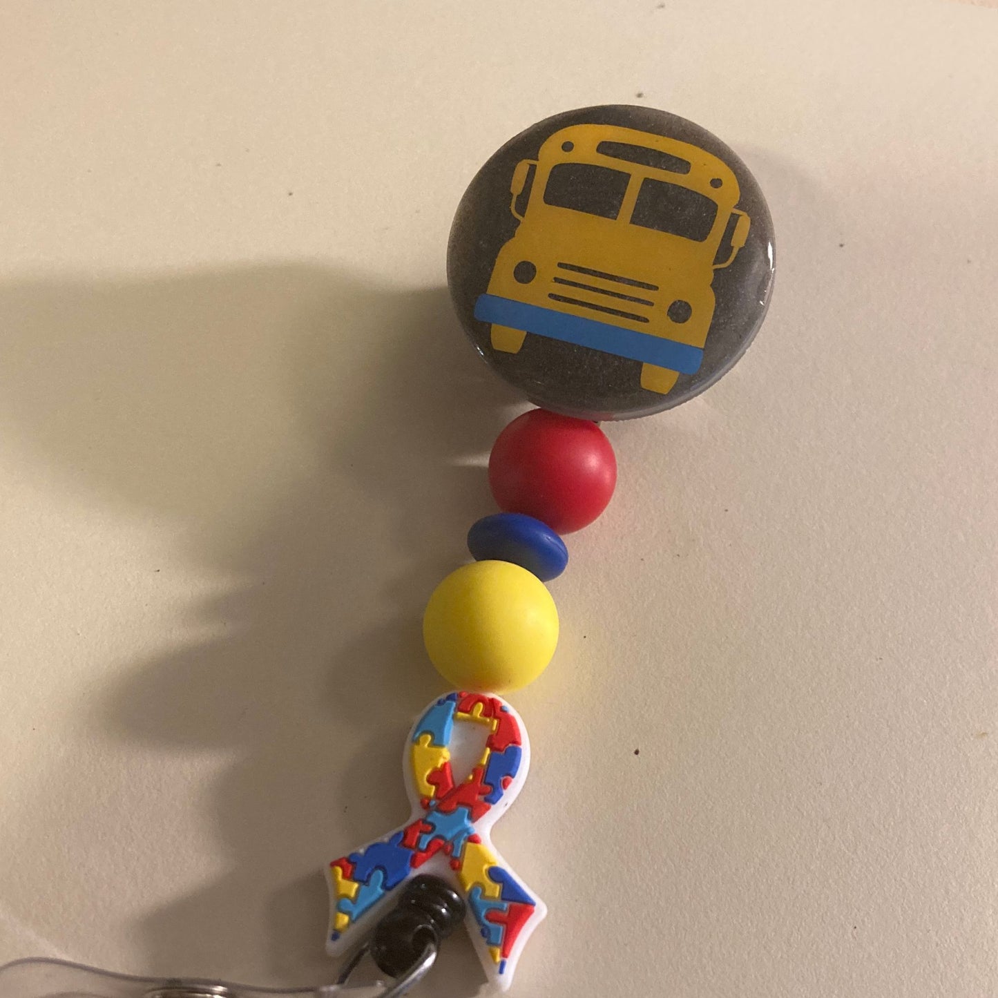 School Bus Cover On Autism Ribbon Beaded Badge Reel